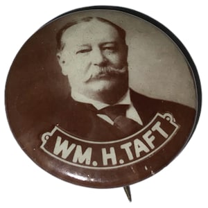 May include: A brown and white button with a portrait of William Howard Taft and the text "WM. H. TAFT" in a white banner.