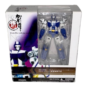 May include: A boxed action figure of a robot, mainly blue and white, with silver detailing. The packaging features text in English and Japanese, with the name "KENRYU" and the phrase "The Collectable Action No. Eleven" visible. The box is white with a clear plastic window.