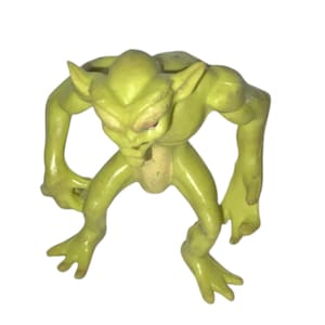 Könnte beinhalten: Hellgrüne Figur einer Kreatur mit großen Ohren, roten Augen und einem bedrohlichen Gesichtsausdruck. Die Figur befindet sich in einer geduckten Position, Arme und Beine sind angewinkelt. Die Figur scheint aus Kunststoff zu sein.