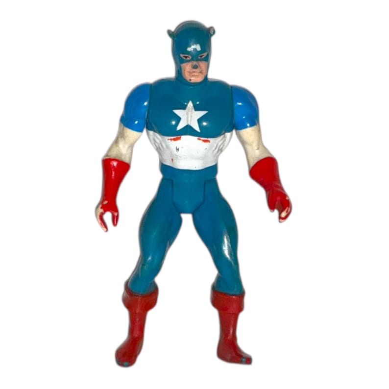 May include: A vintage action figure of a superhero in a blue and white costume with a star emblem. The figure has red gloves and boots. The head is blue with a mask and bear ears.