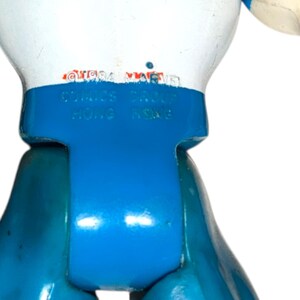 May include: Close-up of a blue and white toy figure. The figure has the text "&copy;1994 MARVEL COMICS GROUP HONG KONG" printed on its back. The toy is made of plastic and has a glossy finish.