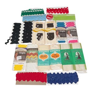 Könnte beinhalten: Eine Sammlung von Vintage-Zickzackbändern und dekorativen Zierleisten in verschiedenen Farben, darunter Grün, Rot, Blau und Schwarz. Mehrere Packungen mit Talon-Reißverschlüssen sind ebenfalls sichtbar. Das Bild zeigt eine Vielzahl von Näh- und Bastelzubehör.