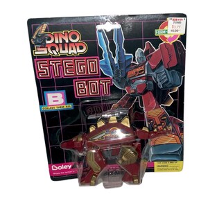 May include: A Dino Squad Stego Bot toy in its original packaging. The toy is a red and gold dinosaur that transforms into a robot. The packaging features the words "Dino Squad" and "Stego Bot".