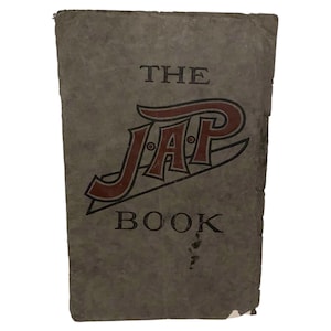 Könnte beinhalten: Vintage Buchcover mit dem Titel "THE JAP BOOK" in auffälliger Schrift. Das Wort "JAP" ist in einer großen, dekorativen Schrift mit roten und schwarzen Akzenten gehalten. Das Cover hat ein abgenutztes, strukturiertes Aussehen.