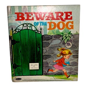 以下が含まれることがあります： 「Beware of the Dog」というタイトルのヴィンテージ子供向けの本。表紙には緑色の門、石壁、本を持って走る女の子が描かれています。タイトルは赤とオレンジ色の文字で書かれています。Whitman出版。