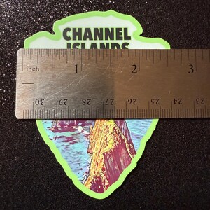 May include: A green and white sticker with a colorful image of a rocky coastline and the text "CHANNEL ISLANDS" in black.