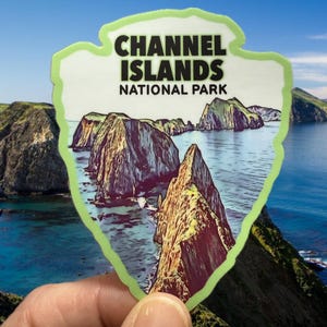 May include: A green and white sticker with a drawing of a rocky island landscape and the text "Channel Islands National Park".