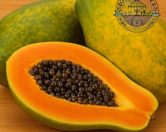 May include: A halved papaya with vibrant orange flesh and dark seeds is displayed alongside two whole papayas. The papayas have a green and yellow skin. The image includes a logo that says "Bowles Acres Seeds".