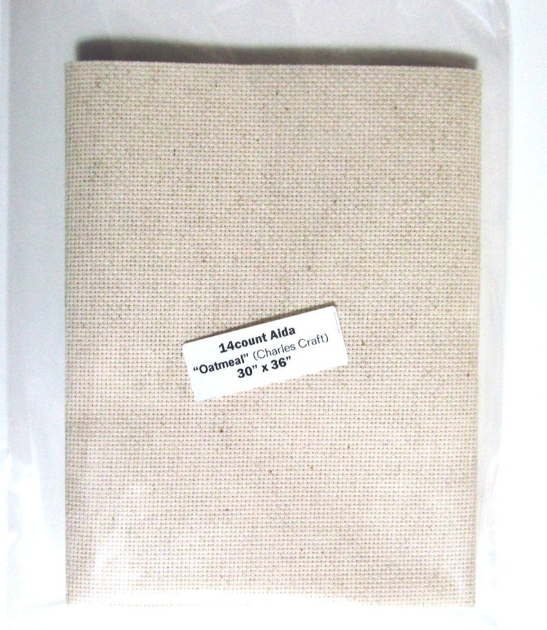 May include: Aida cloth in a neutral oatmeal color, packaged in clear plastic. The label reads "14 count Aida 'Oatmeal'" and lists the dimensions as 30" x 36" (76.2 cm x 91.4 cm). Ideal for cross-stitch and embroidery projects.