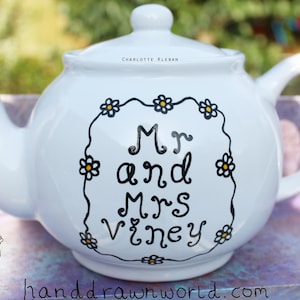 May include: White teapot with black and yellow daisy accents and the text "Mr and Mrs Viney" painted on the front.