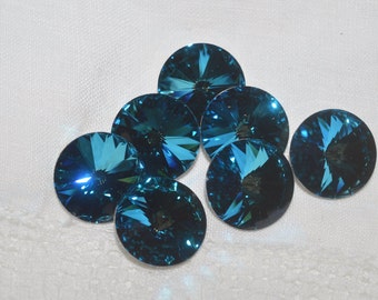May include: A group of seven teal blue round rhinestones with a faceted design.