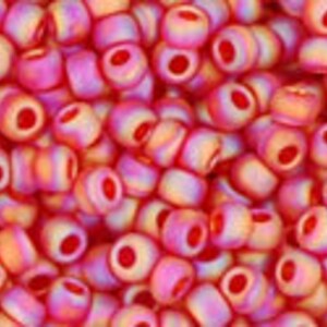 May include: A close-up of a pile of small, round, iridescent beads. The beads are a mix of pink and orange colors with a subtle shimmer.