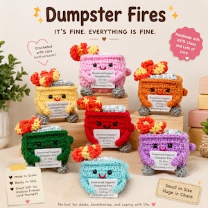 May include: A collection of seven crocheted dumpster fire figures in various colours including pink, yellow, orange, red, green, purple, and light blue. Each figure features a small flame on top, a smiling face, and holds a white sign with text.