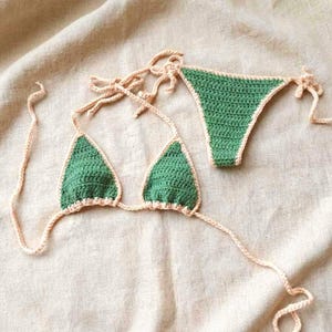 May include: A white ceramic mug with a black handle and the text "But First, Coffee" in a bold, black font. The mug is set against a neutral background, highlighting its simple design.