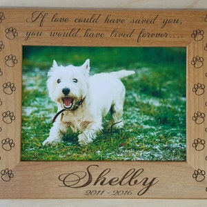 May include: A wooden photo frame with a paw print border. The frame holds a photo of a white dog running through grass. The frame is engraved with the text "If love could have saved you, you would have lived forever..." and "Shelby 2011-2016".