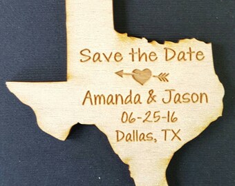 Könnte beinhalten: Ein Holzausschnitt des Bundesstaates Texas mit dem Text "Save the Date" und einem Pfeil mit einem Herzen. Unter dem Text steht "Amanda & Jason", "06-25-16" und "Dallas, TX".