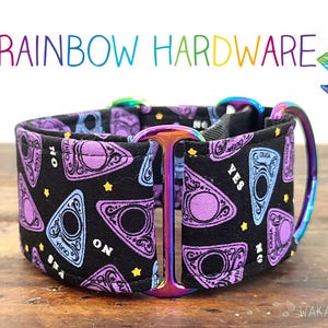 Puede incluir: Un collar negro para perros con un patrón de tablero Ouija morado y herrajes arcoíris. El collar tiene una anilla en D de metal y una pieza metálica curvada. El texto "Rainbow Hardware" está en la parte superior.
