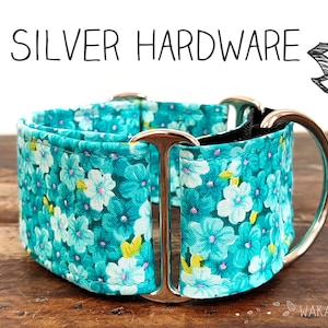 May include: A dog collar with silver hardware. The collar features a teal floral pattern with white and yellow accents. The text "SILVER HARDWARE" is displayed above the collar.