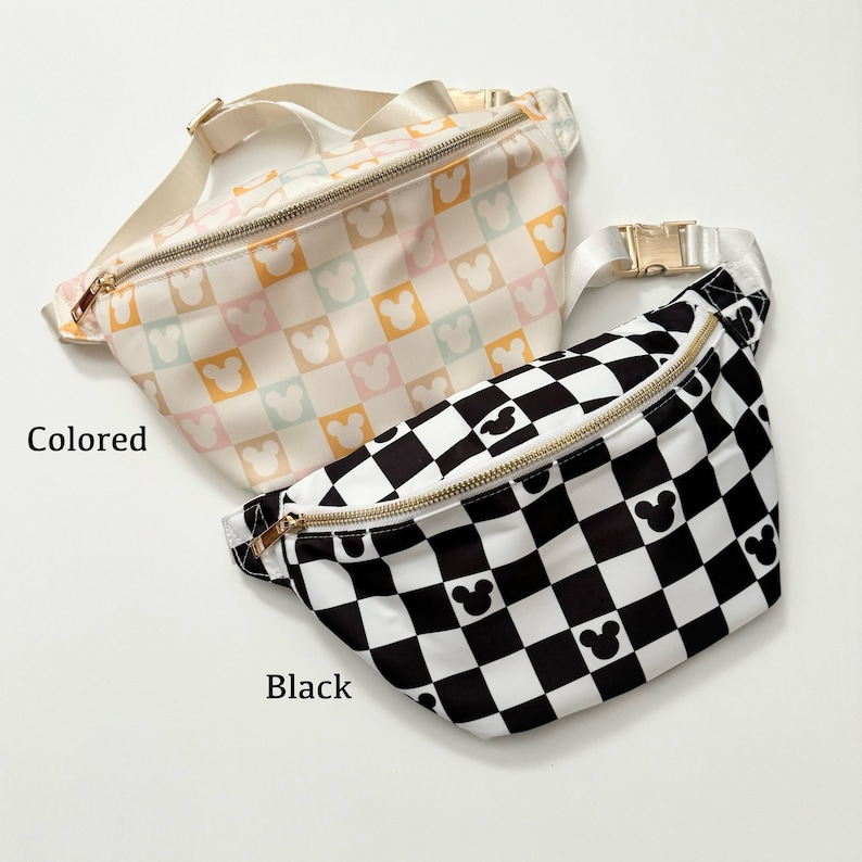 May include: Two fanny packs with gold zippers and adjustable straps. One is a pastel checkered pattern with Mickey Mouse silhouettes. The other is a black and white checkered pattern with Mickey Mouse silhouettes. The word "Colored" is printed on the left side of the pastel fanny pack. The word "Black" is printed on the left side of the black fanny pack.