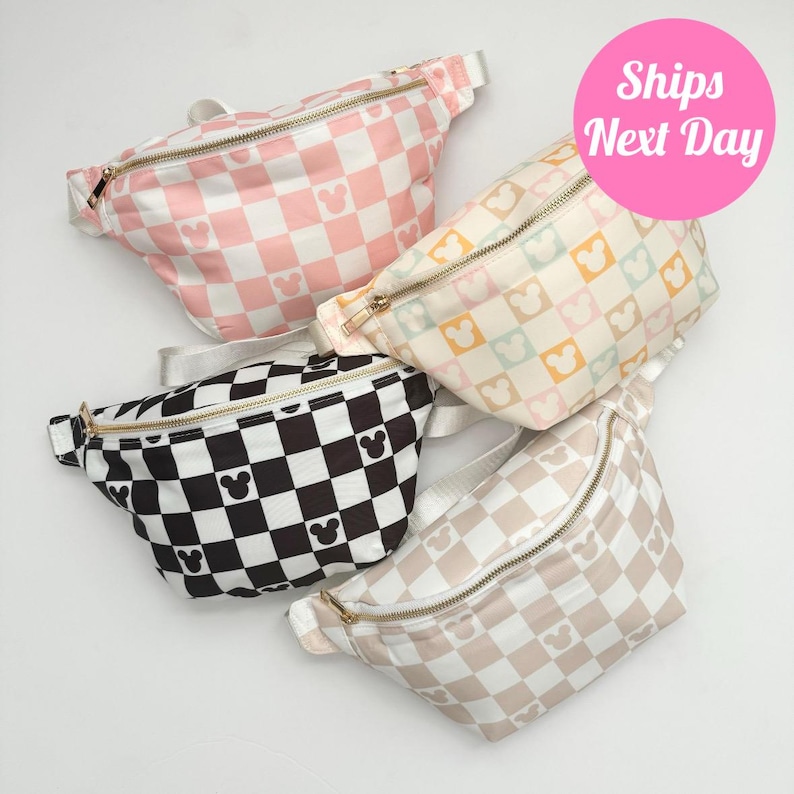 May include: Four fanny packs in various colors: pink, cream, black, and tan. Each pack features a checkered pattern with Mickey Mouse silhouettes. The bags have gold zippers and white straps, perfect for carrying essentials.