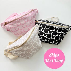 Könnte beinhalten: Drei Bauchtaschen mit einem karierten Muster und Mickey-Maus-Köpfen. Die Bauchtaschen sind rosa, schwarz-weiß und beige-weiß.