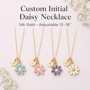 May include: Four gold necklaces with daisy pendants in blue, pink, purple, and white, each with a gold initial charm. The necklaces are adjustable from 12 to 18 inches and are 14k gold. The text reads "Custom Initial Daisy Necklace".