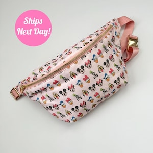 May include: A pink fanny pack with a zipper closure and a repeating pattern of Mickey Mouse, Minnie Mouse, Donald Duck, and Goofy characters.