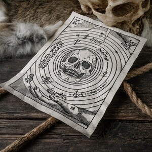 K&ouml;nnte beinhalten: Ein Pergamentpapier im Vintage-Stil mit einem Totenkopf- und Knochenkreuz-Design. Das Pergament ist von einem Kreis aus Text und Symbolen umgeben. Das Pergament liegt auf einer Holzoberfl&auml;che.