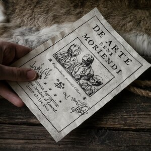 K&ouml;nnte beinhalten: Ein altes, gealtertes Papierdokument mit dem Titel "De Arte Bene Moriendi" und einer Holzschnitt-Illustration von drei Figuren in Kapuzenroben. Der Text unter dem Bild lautet "Stipendium Peccati Mors" und "Coloni&aelig; Agrippin&aelig; Apud Cornelium ab Egmond. Anno clo loc XXVI."