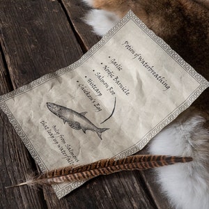 Może przedstawiać: Ręcznie napisany przepis na miksturę do oddychania pod wodą, napisany na kawałku pergaminu. Składniki obejmują czosnek, nordyckie skorupiaki, ikrę łososiową, histcarp i jajko kurze. Pergamin leży na drewnianej powierzchni z pi&oacute;rem i kawałkiem futra.