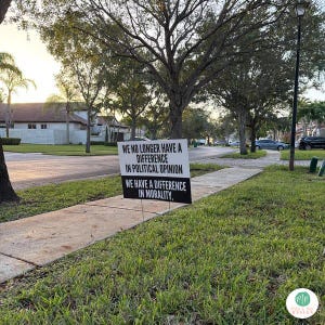 anti trump yard sign in front yard grass by sidewalk