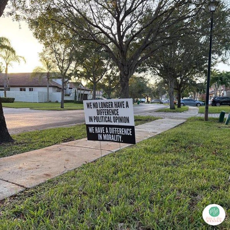 anti trump yard sign in front yard grass by sidewalk