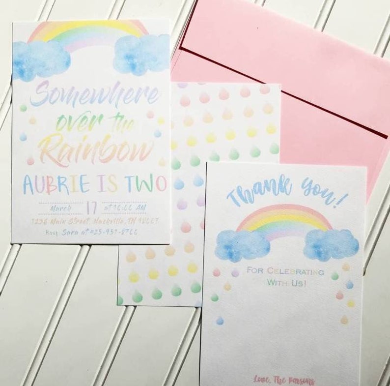 Puede incluir: Un conjunto de invitaciones y tarjetas de agradecimiento para fiestas con tem&aacute;tica de arco&iacute;ris pastel. La invitaci&oacute;n dice "Somewhere over the Rainbow, Aubrie is Two". La tarjeta de agradecimiento presenta un arco&iacute;ris y las palabras "Thank you!"