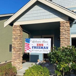 welcome home military banner hung in front of house, personalized with name, rank and homecoming message