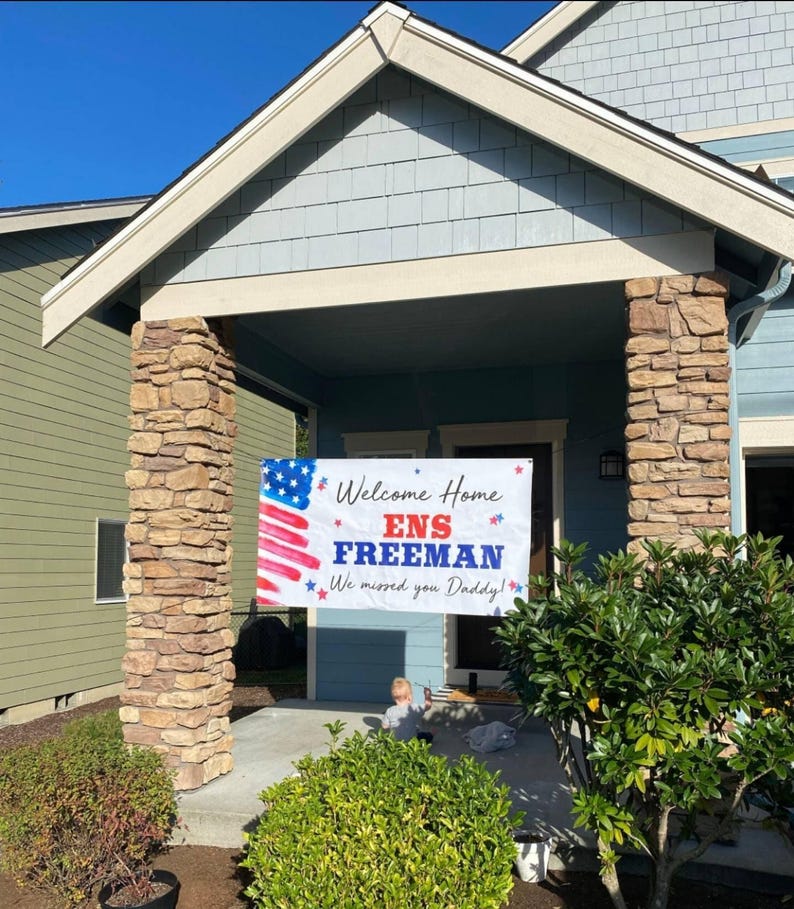 welcome home military banner hung in front of house, personalized with name, rank and homecoming message