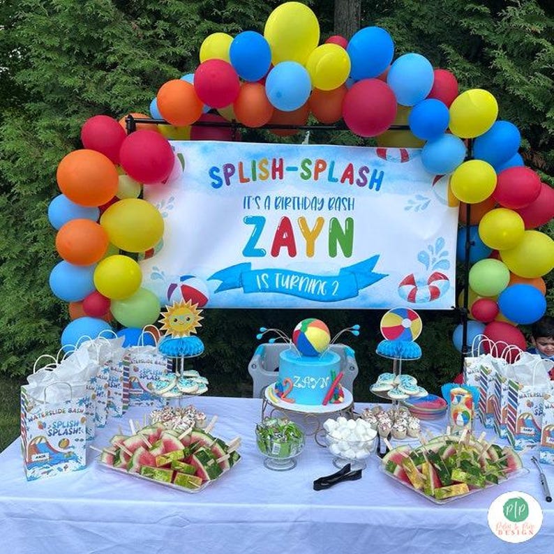 Kids summer birthday party with Splish splash theme and beach balls, includes a personalized banner, balloon garland and dessert table