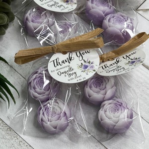 May include: Thank you favor bags with purple floral soap and a round white tag with the text "Thank you for showering Danielle & Greg with love! 4-16-24".