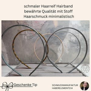May include: Four thin headbands in various textures and colors, including a dark grey textured band, a yellow and black speckled band, a plain beige band, and a black and white patterned band, arranged upright in a grey display tray.
