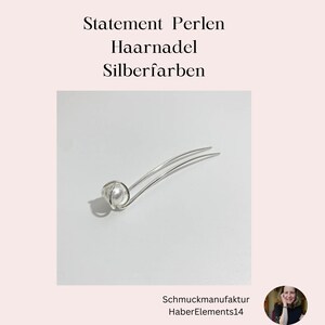 Puede incluir: Horquilla de pelo plateada con una sola perla blanca. La perla est&aacute; rodeada de un alambre plateado. La horquilla se llama "Statement Perlen Haar Nadel Silberfarben".