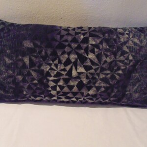 May include: A black and grey geometric patterned throw pillow. The pillow is made of a soft, plush fabric.