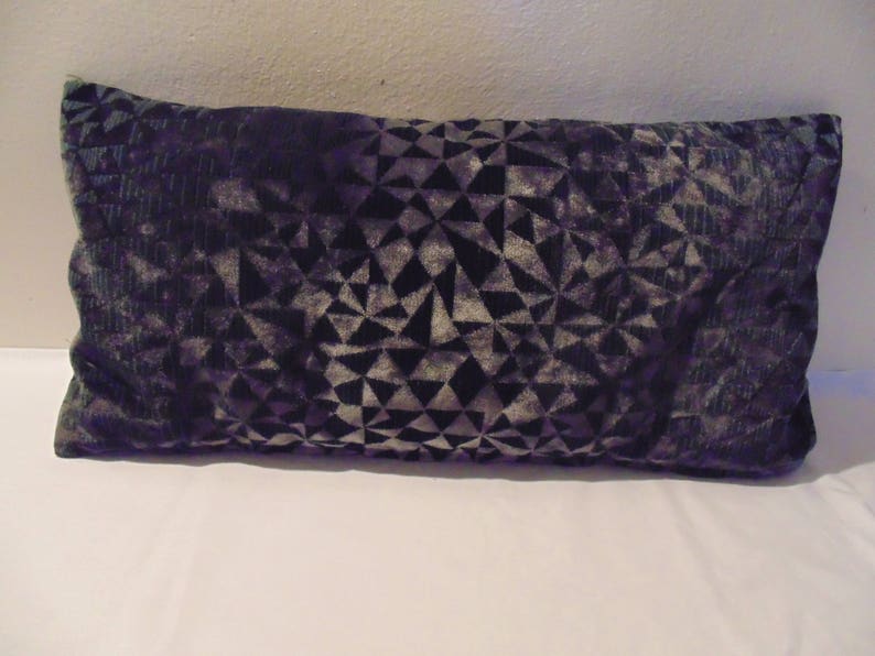 May include: A black and grey geometric patterned throw pillow. The pillow is made of a soft, plush fabric.