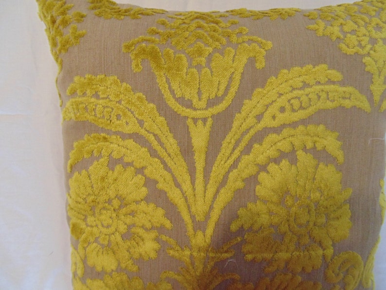 May include: A decorative throw pillow with a beige background and a yellow floral pattern.