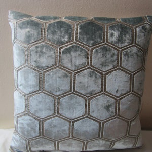 May include: A light blue throw pillow with a geometric pattern of gold hexagons.