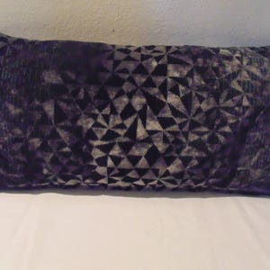 May include: A black and grey geometric patterned throw pillow. The pillow is made of a soft, velvety fabric.