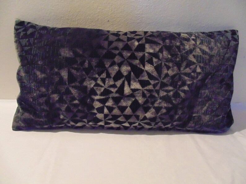 May include: A black and grey geometric patterned throw pillow. The pillow is made of a soft, velvety fabric.