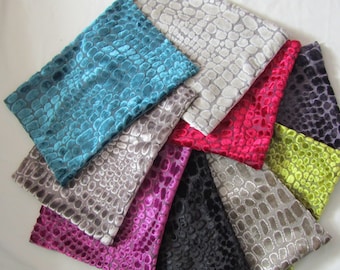 May include: Assortment of fabric swatches in various colours and patterns. The fabric has a textured, raised design resembling a snakeskin pattern. The colours include teal, grey, pink, red, black, green, and purple.