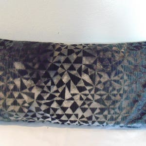 May include: A decorative cushion with a geometric pattern in shades of green, black and grey.