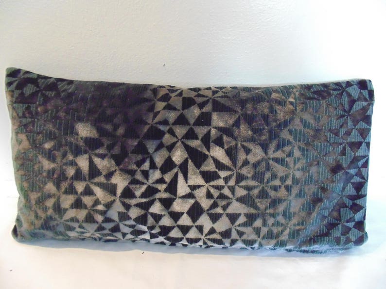 May include: A decorative cushion with a geometric pattern in shades of green, black and grey.