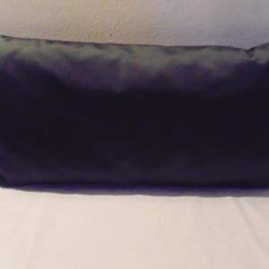 May include: A plain black rectangular cushion with a smooth, satin-like fabric.