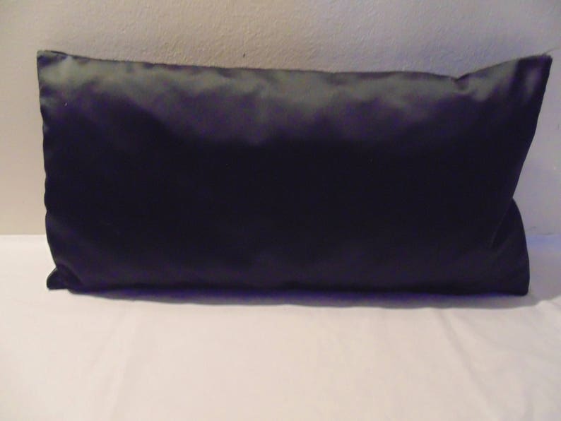 May include: A plain black rectangular cushion with a smooth, satin-like fabric.